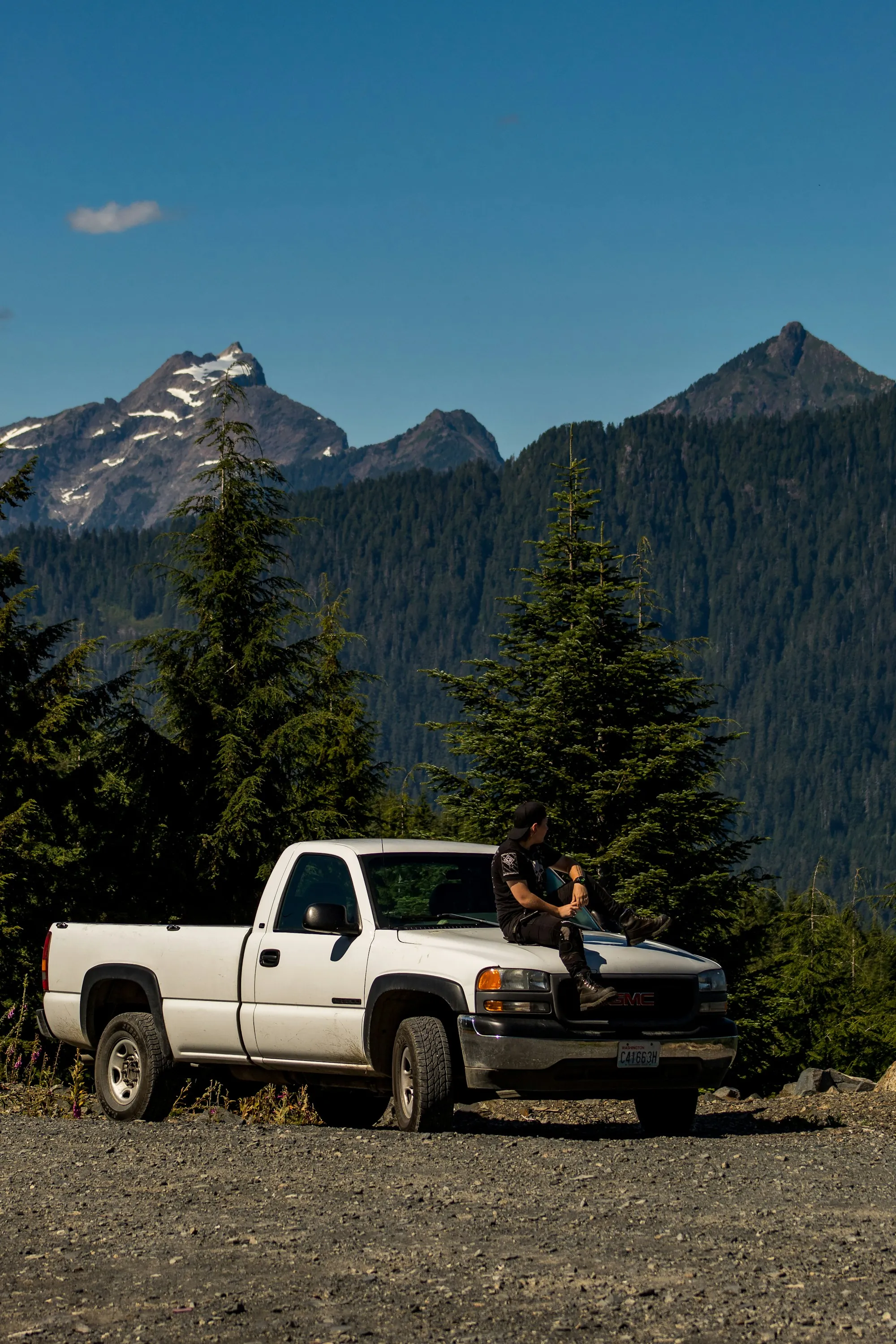 Pickup truck parked on a gravel overlook with mountains behind